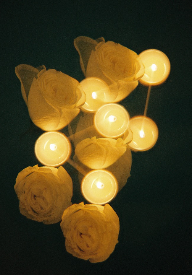 analogue photograph of candles and white roeses