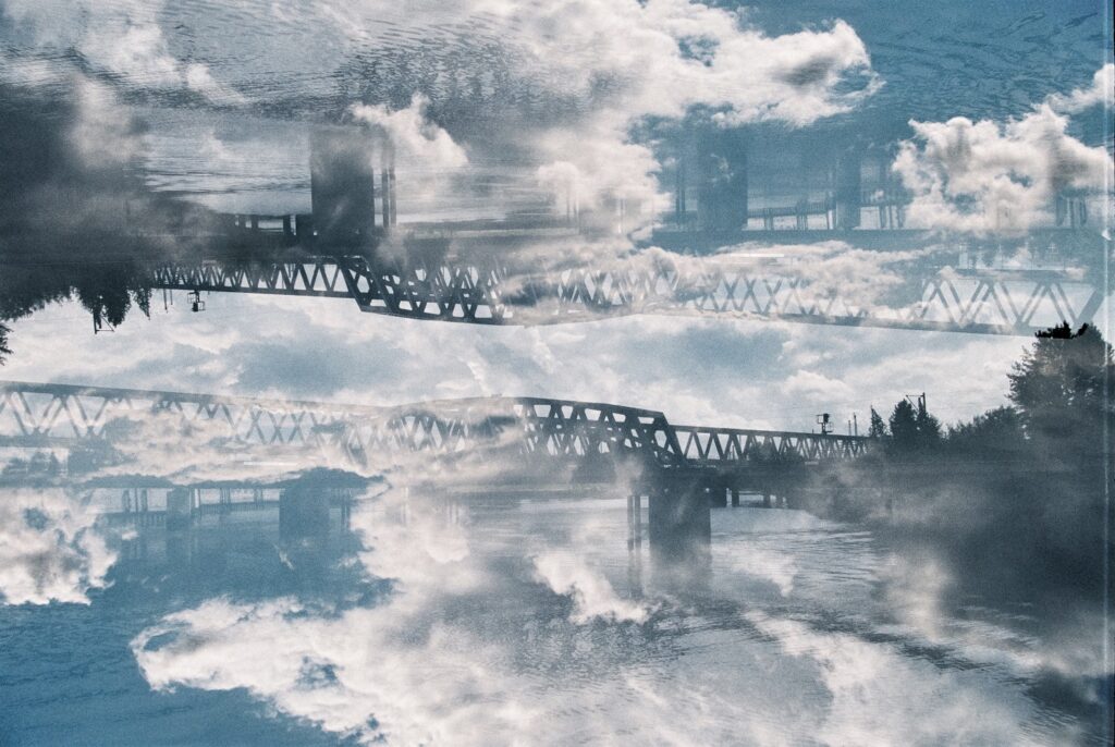 Analoge Doppelbelichtung von Wolken und einer Brücke